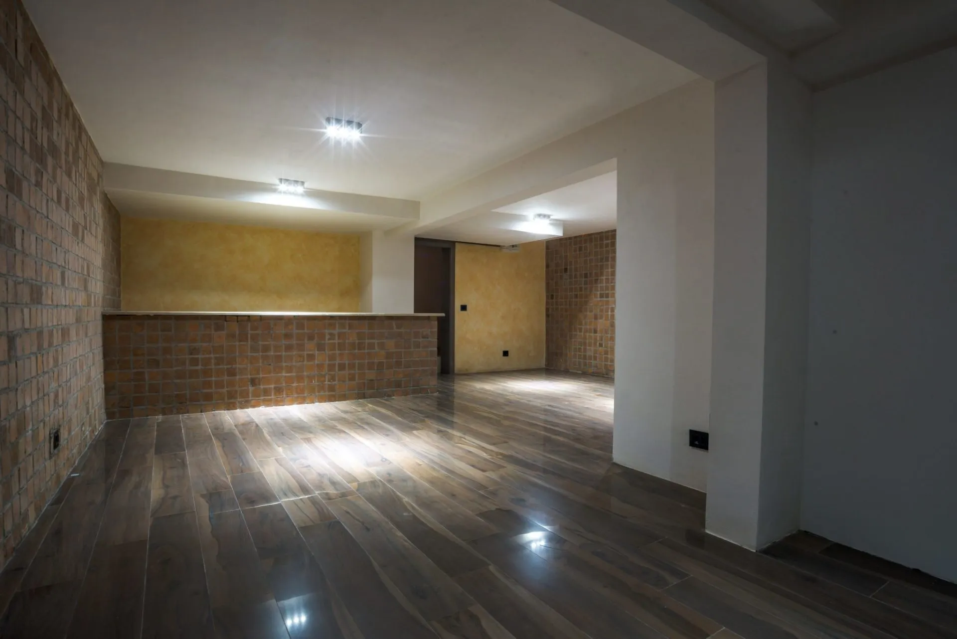 Wohnzimmer mit Bartheke, Ziegelverkleidung und Holzoptikfliesen in einer Villa in Budva, Montenegro.