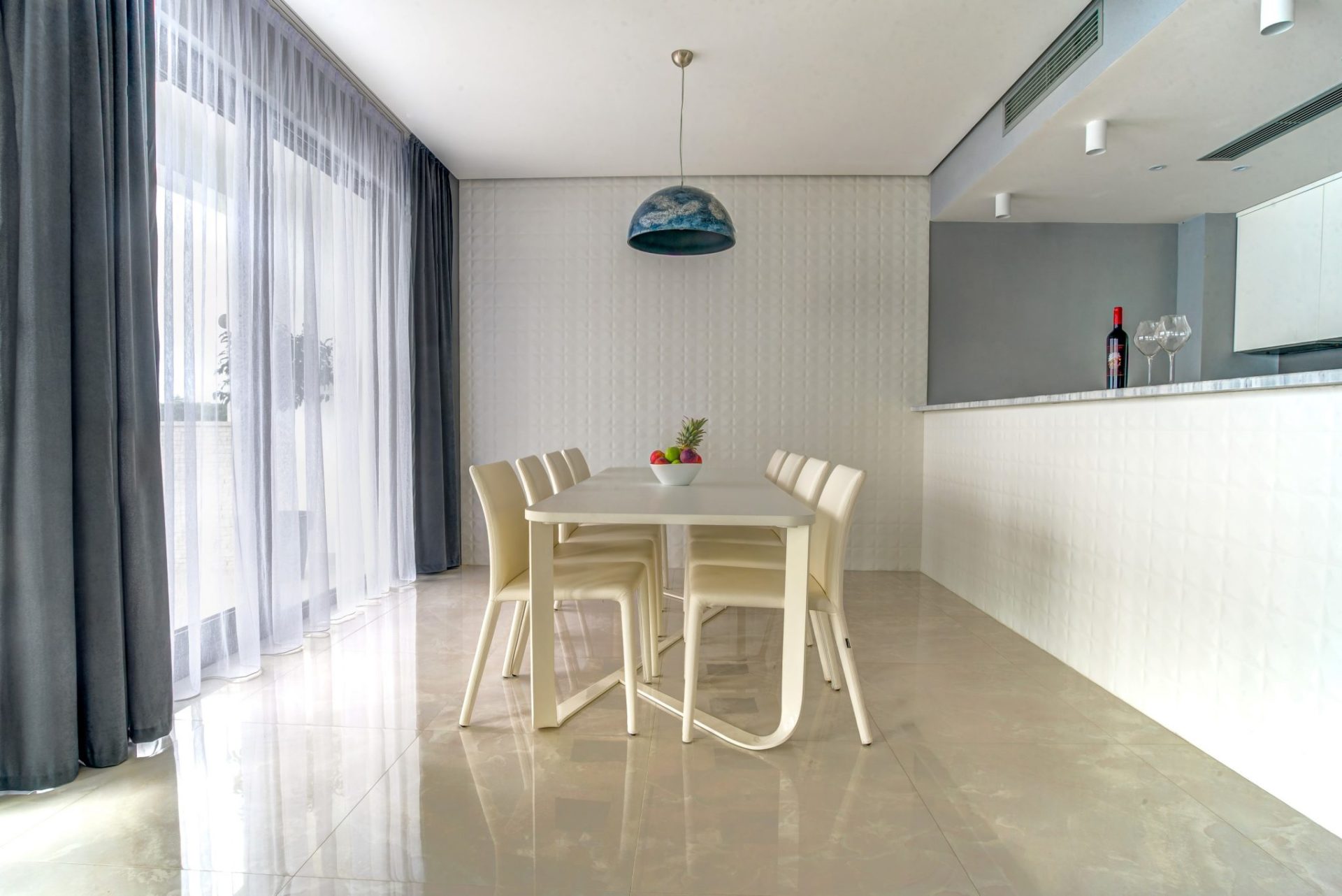 Moderner Essbereich mit weißem Tisch und Stühlen im Interieur einer Villa in Budva, Montenegro. Panoramafenster und Dekor.