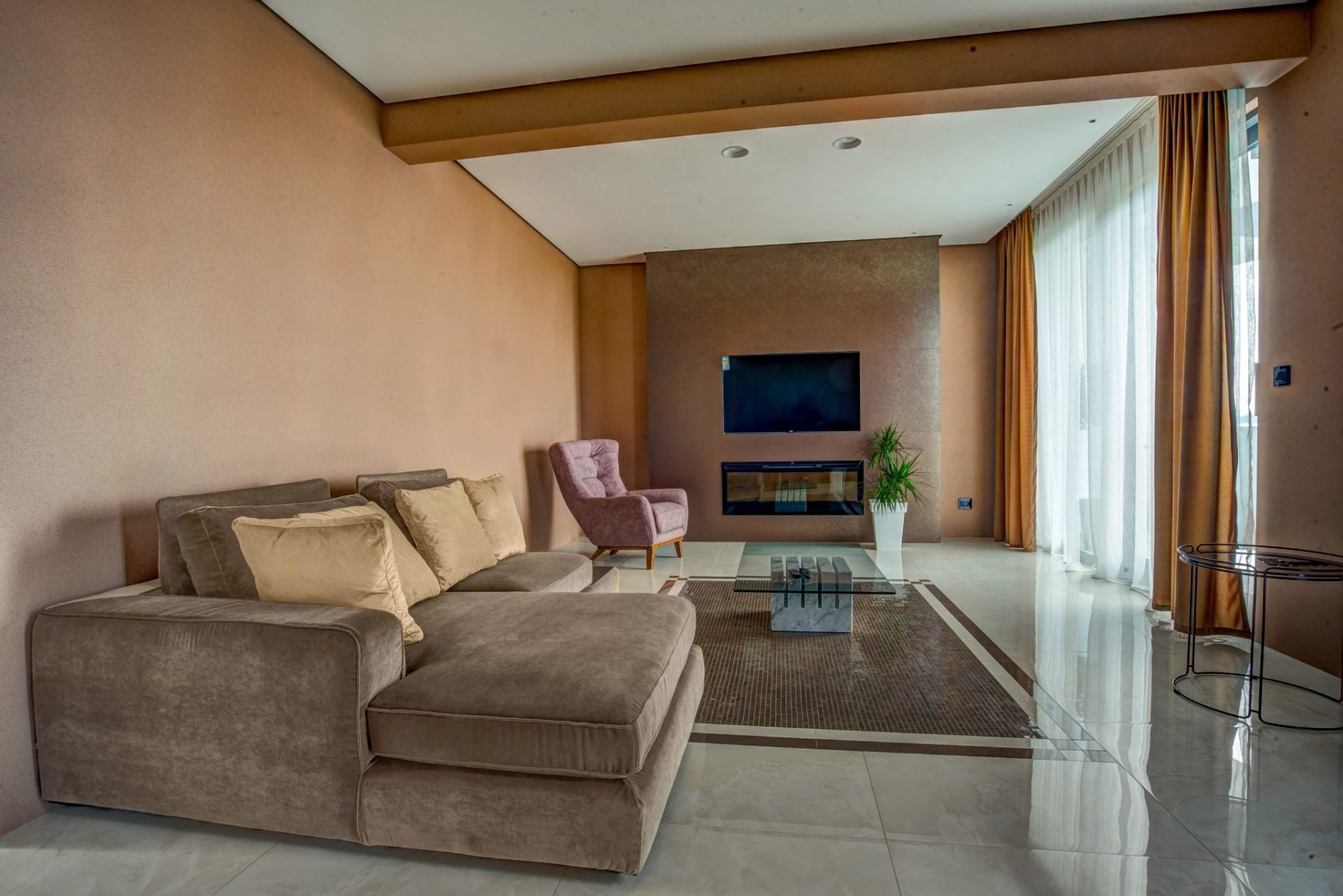 Modernes Wohnzimmer mit Kamin und Polstermöbeln in einer exklusiven Villa in Budva, Montenegro. Innenraum mit Panoramafenstern.