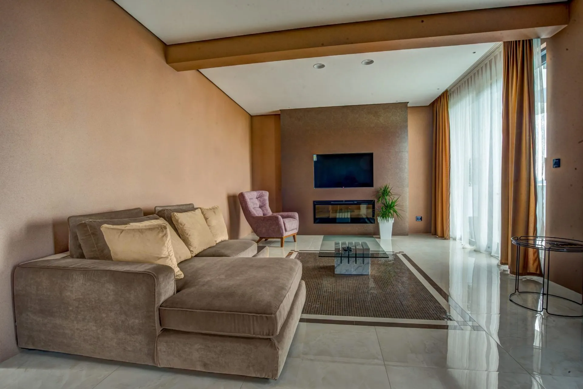 Modernes Wohnzimmer mit Kamin und Polstermöbeln in einer exklusiven Villa in Budva, Montenegro. Innenraum mit Panoramafenstern.