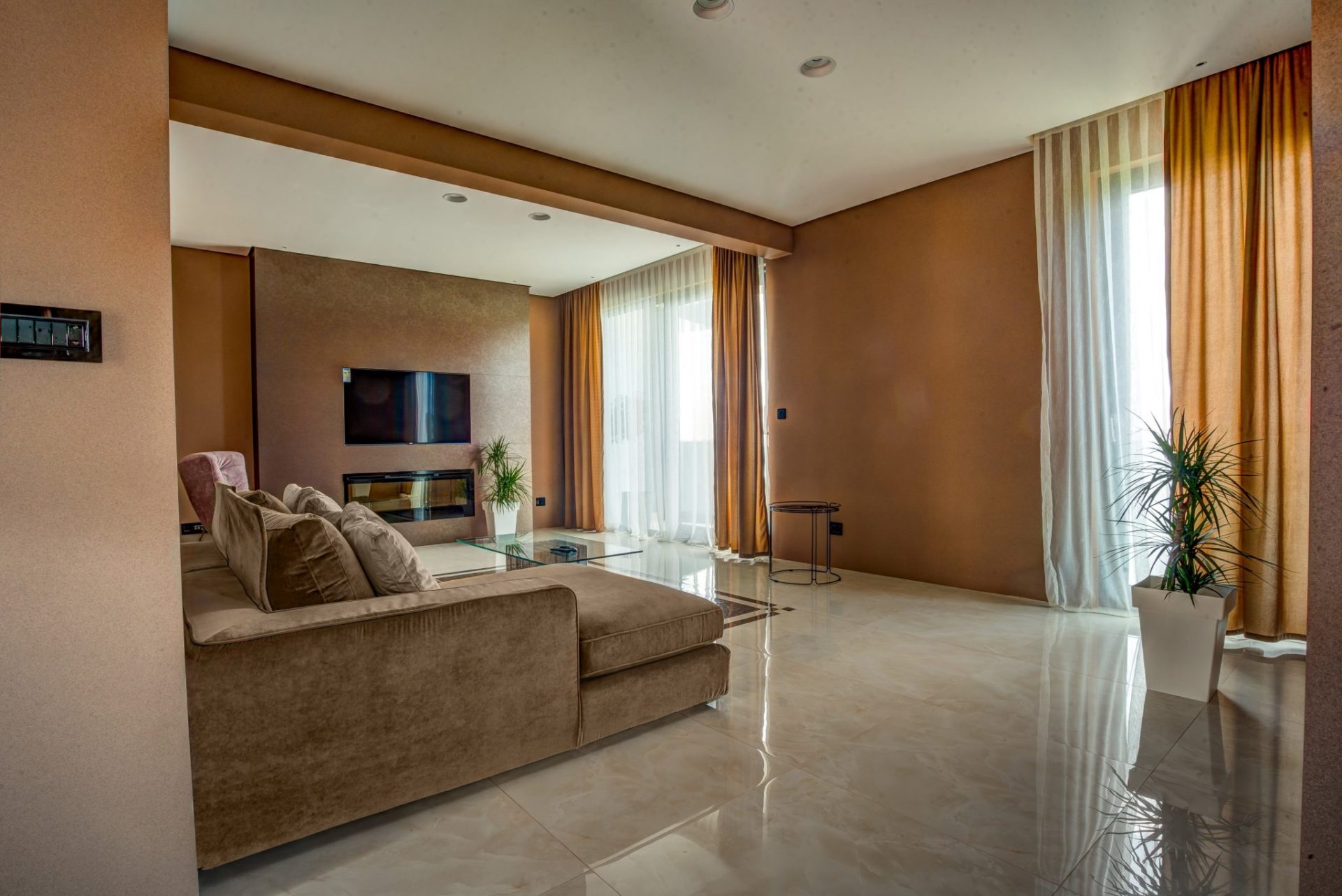 Modernes Wohnzimmer mit Kamin und weichem Sofa in einer Villa in Budva, Montenegro: stilvolles Interieur, Panoramafenster.