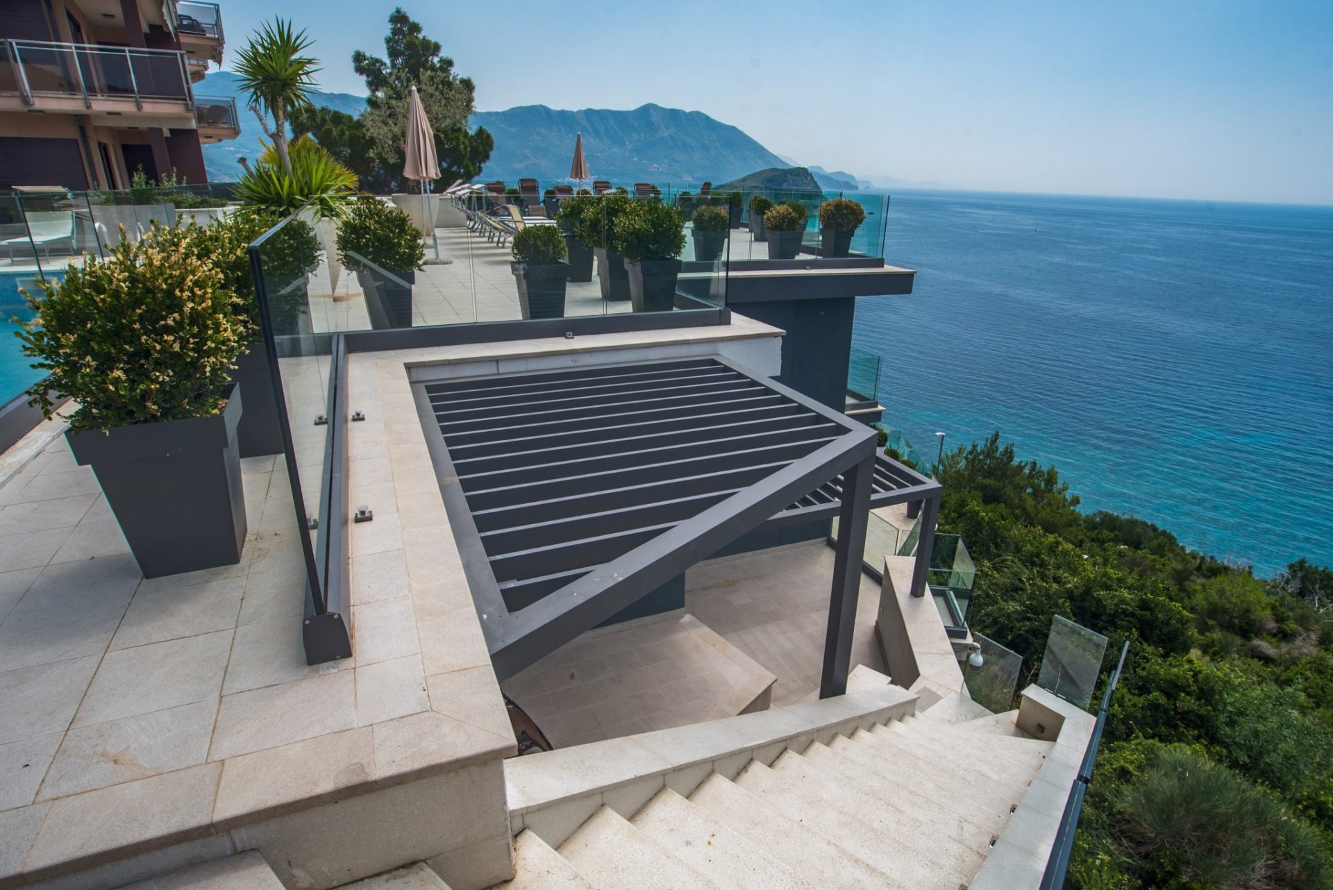 Terrasse der Villa in Budva, Montenegro: Panoramablick auf das Meer, moderne Pergola, Glasgeländer und Landschaftsgestaltung.