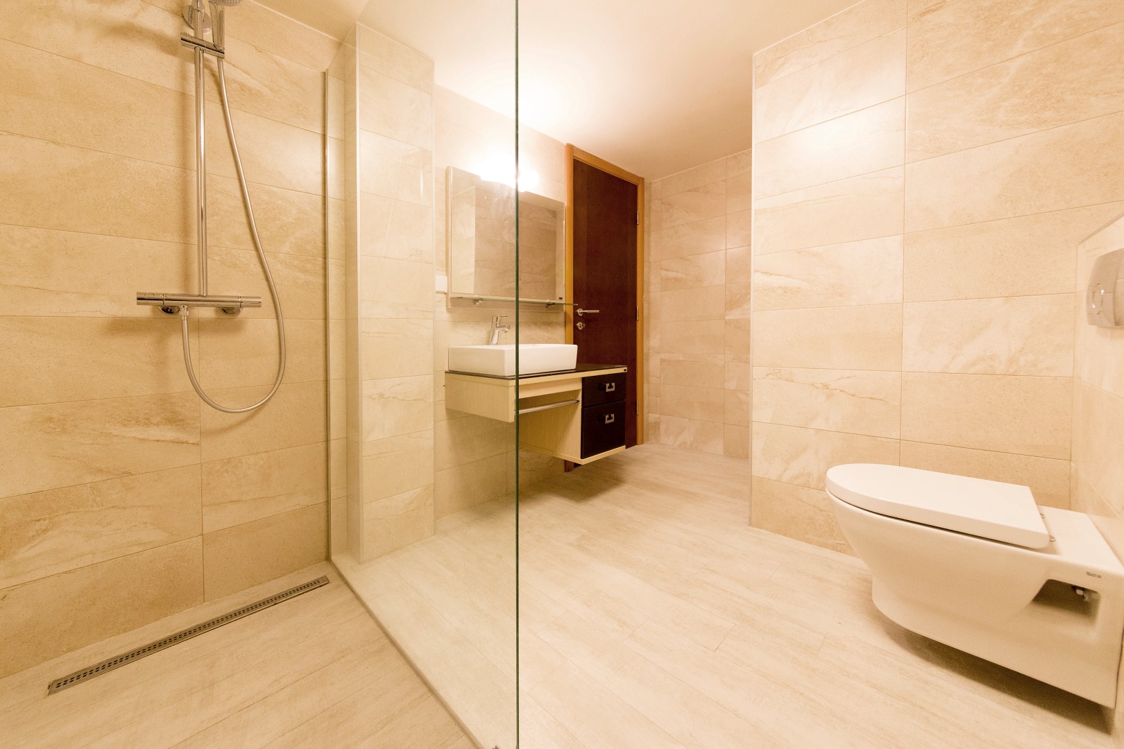 Modern bathroom with a shower cabin in a villa in Krašići, Montenegro: beige tiles and fixtures.