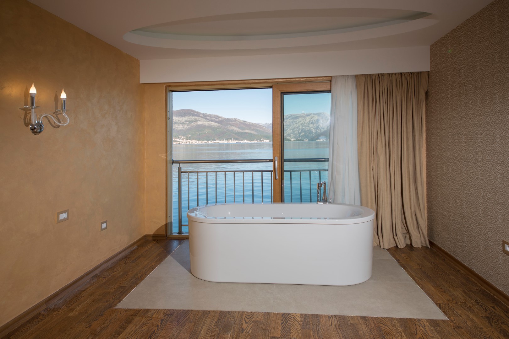 Bathroom with a freestanding bathtub and panoramic sea and mountain views, villa in Krašići, Montenegro.