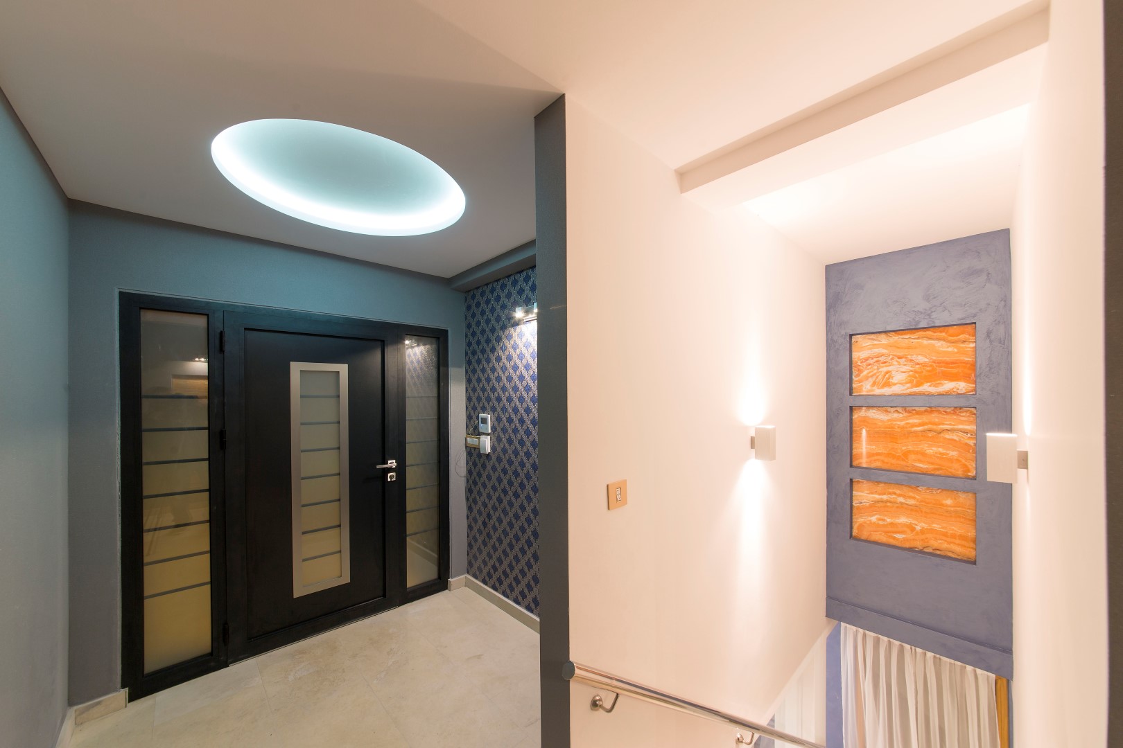 Modern villa entryway in Krašići, Montenegro: stylish front door, designer lighting, and wall decor.