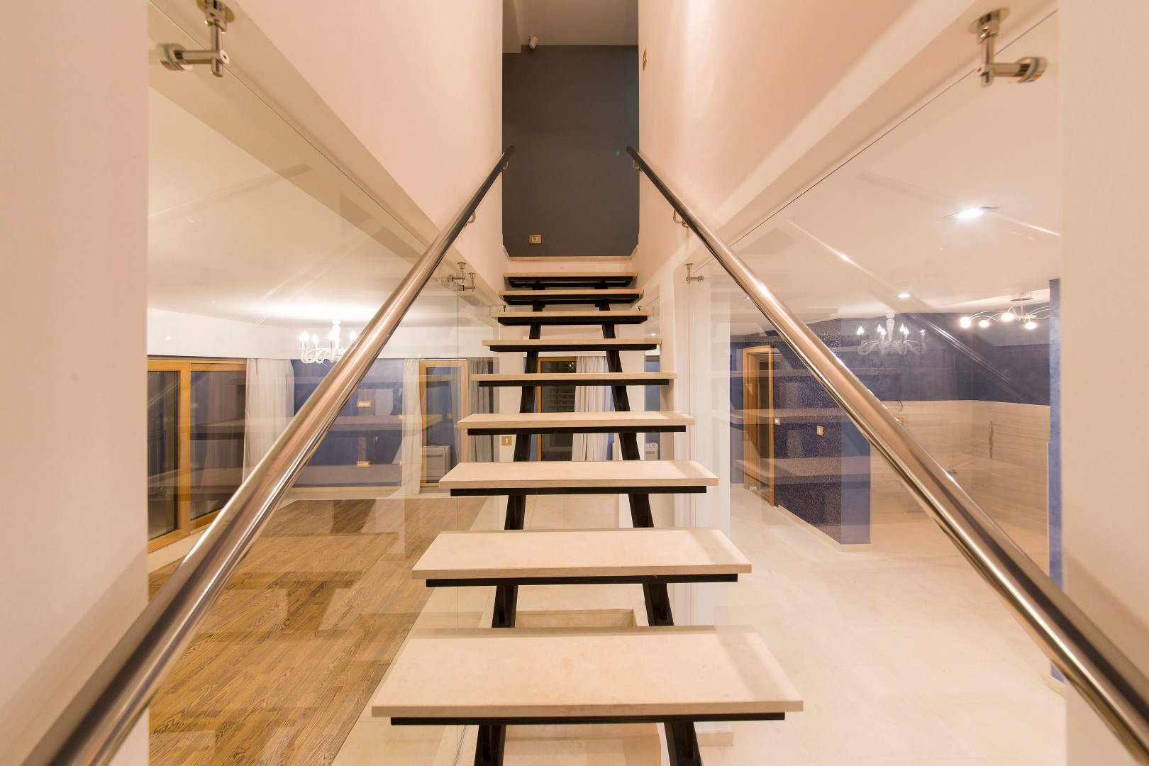 Modern staircase with wooden steps and glass railing in the interior of a villa in Krašići, Montenegro.