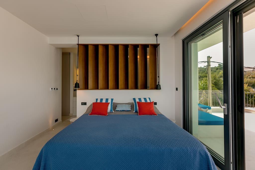 Modernes Schlafzimmer mit Doppelbett und Zugang zur Terrasse in einer Villa in Luštica, Montenegro.