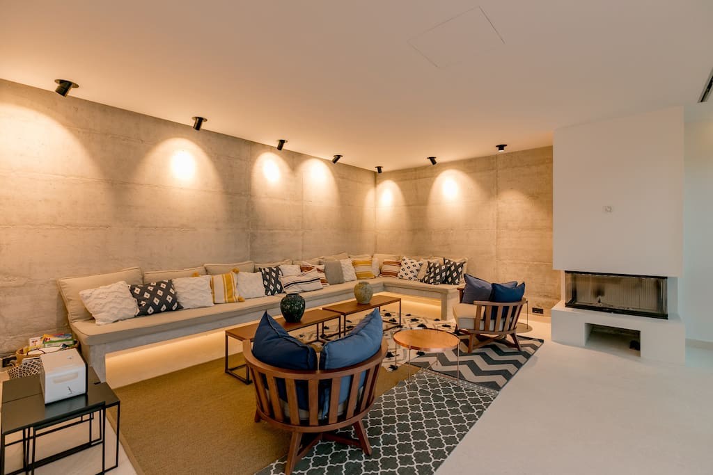 Modernes Wohnzimmer mit Betonwänden, Kamin und Polstermöbeln in einer Villa in Luštica, Montenegro.