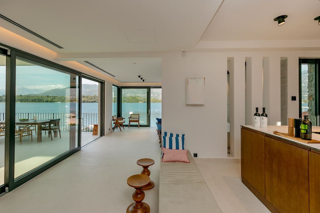 Wohnzimmer der Villa in erster Meereslinie in Luštica, Montenegro: Panoramafenster mit Meerblick, modernes Design und Terrasse.