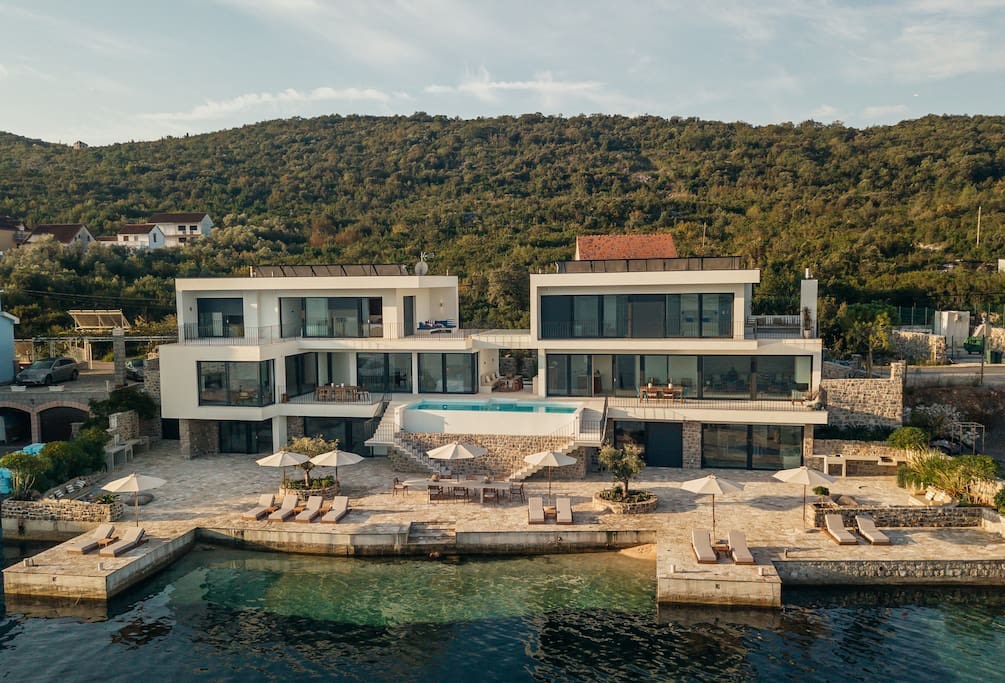 Moderne Villa in erster Meereslinie in Luštica, Montenegro: Pool, Terrasse mit Liegestühlen und privater Zugang zum Meer.