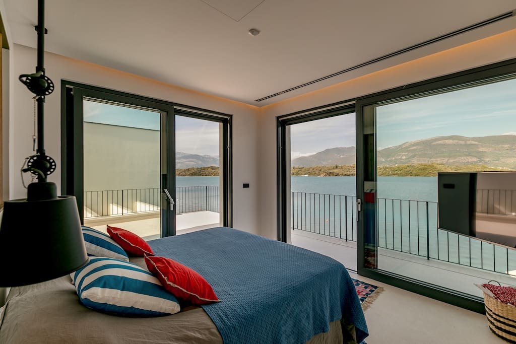Schlafzimmer mit Panoramablick auf das Meer und die Berge in einer Villa in Luštica, Montenegro: modernes Interieur, Zugang zur Terrasse.