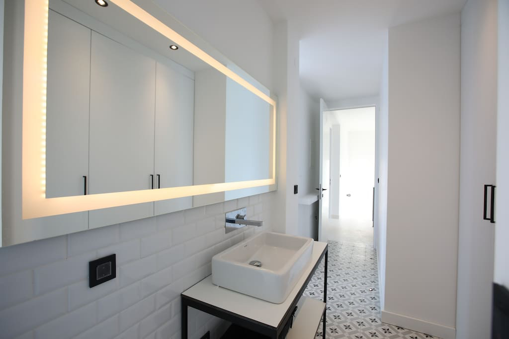 Modernes Badezimmer in einer Villa in Luštica, Montenegro: Aufsatzwaschbecken, beleuchteter Spiegel und Fliesen im Patchwork-Stil.