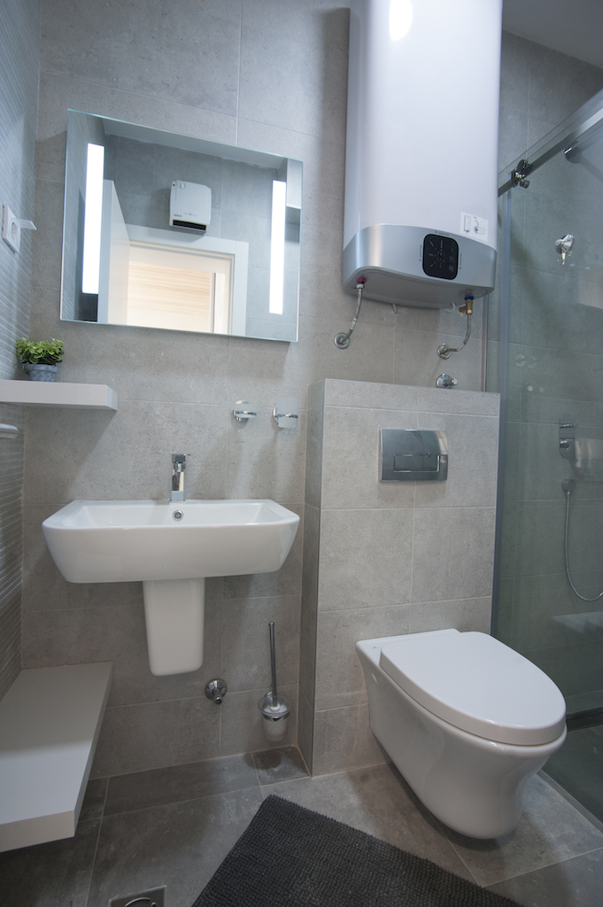 Modernes Badezimmer in einer Wohnung, Budva, Montenegro: Duschkabine, wandhängendes WC und Boiler.