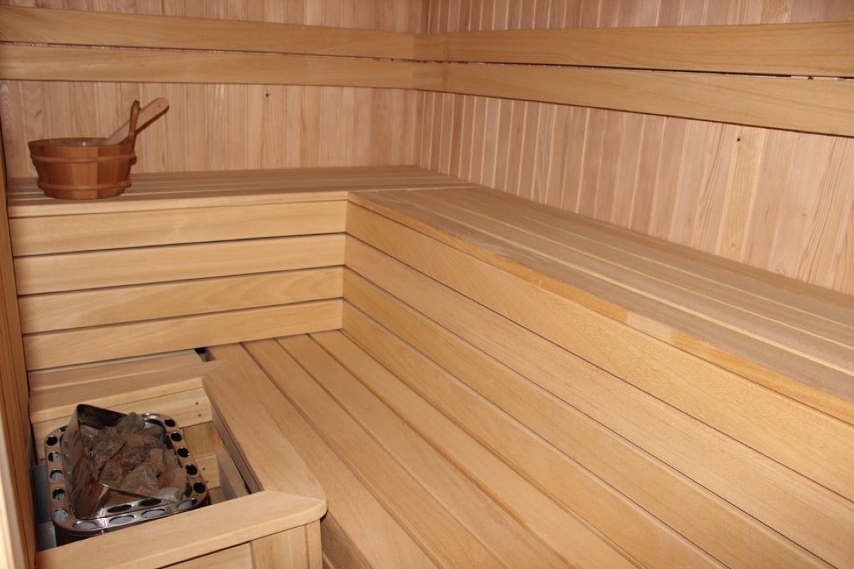 Innenraum einer modernen Sauna mit Holzverkleidung und Ofen in einer Villa in Budva, Montenegro.