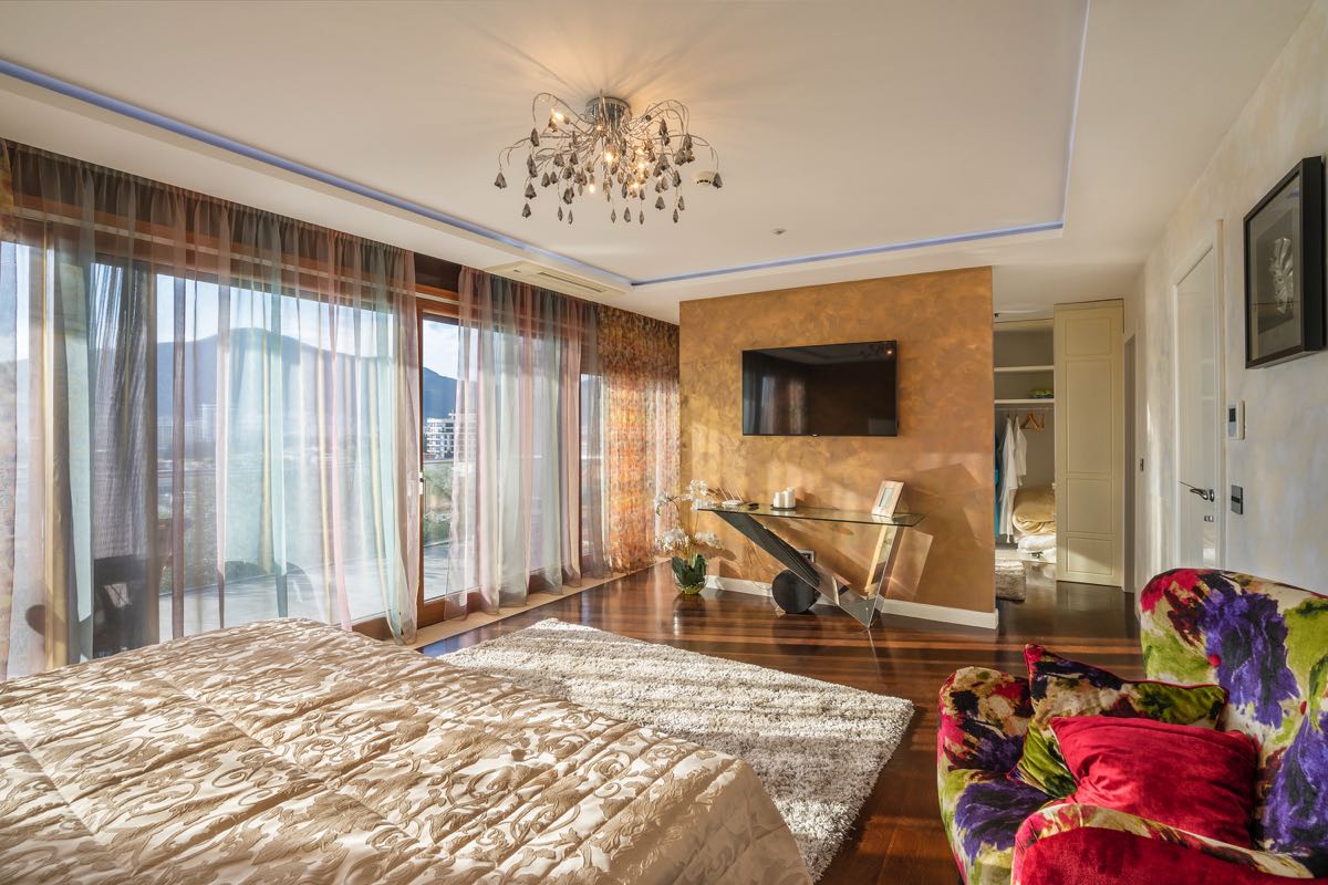 Schlafzimmer mit Panoramafenstern in einer Villa in Budva, Montenegro: Designermöbel, TV und Ankleidebereich.