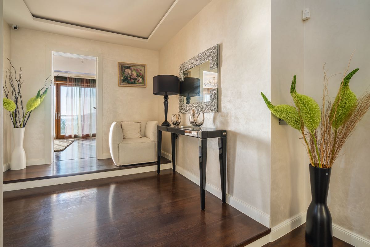 Helle Diele einer Villa in Budva, Montenegro: dunkles Parkett, Konsolentisch, Spiegel und stilvolle Innendekoration.