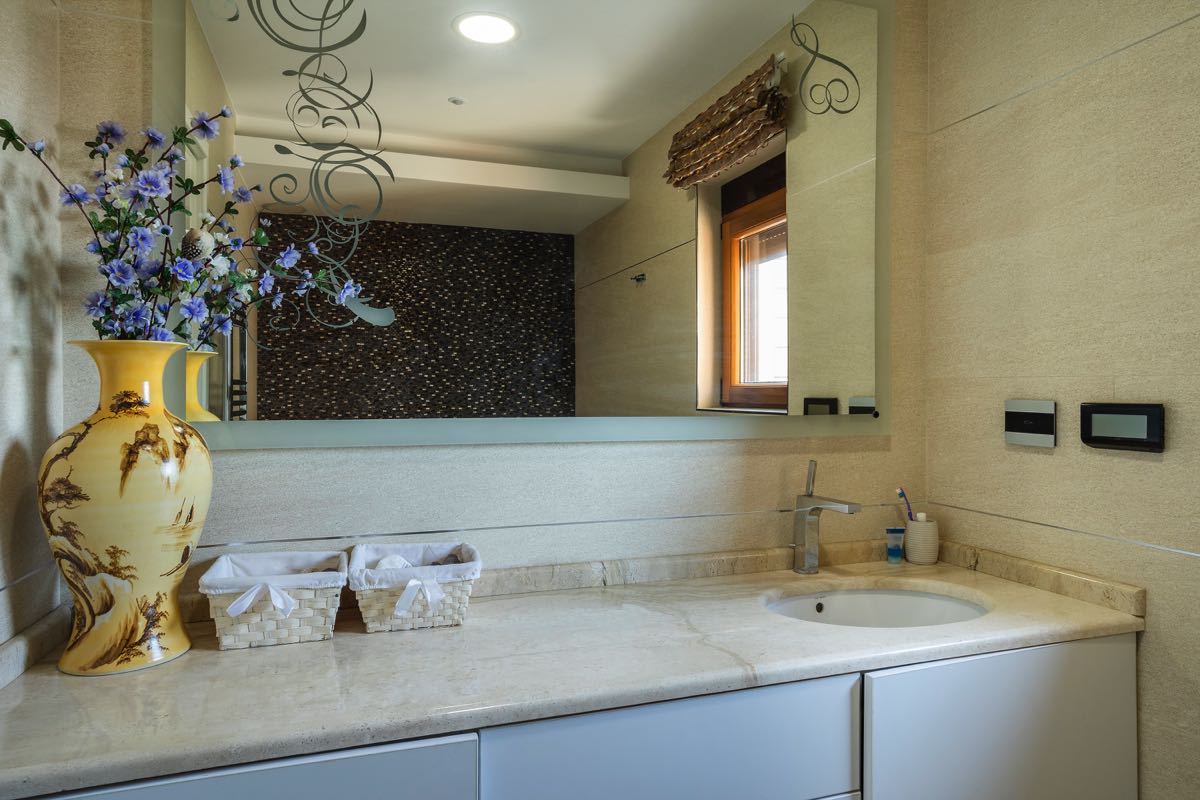 Modernes Badezimmer mit Marmorarbeitsplatte und Spiegel in einer Villa in Budva, Montenegro. Stilvolles Badezimmerinterieur.