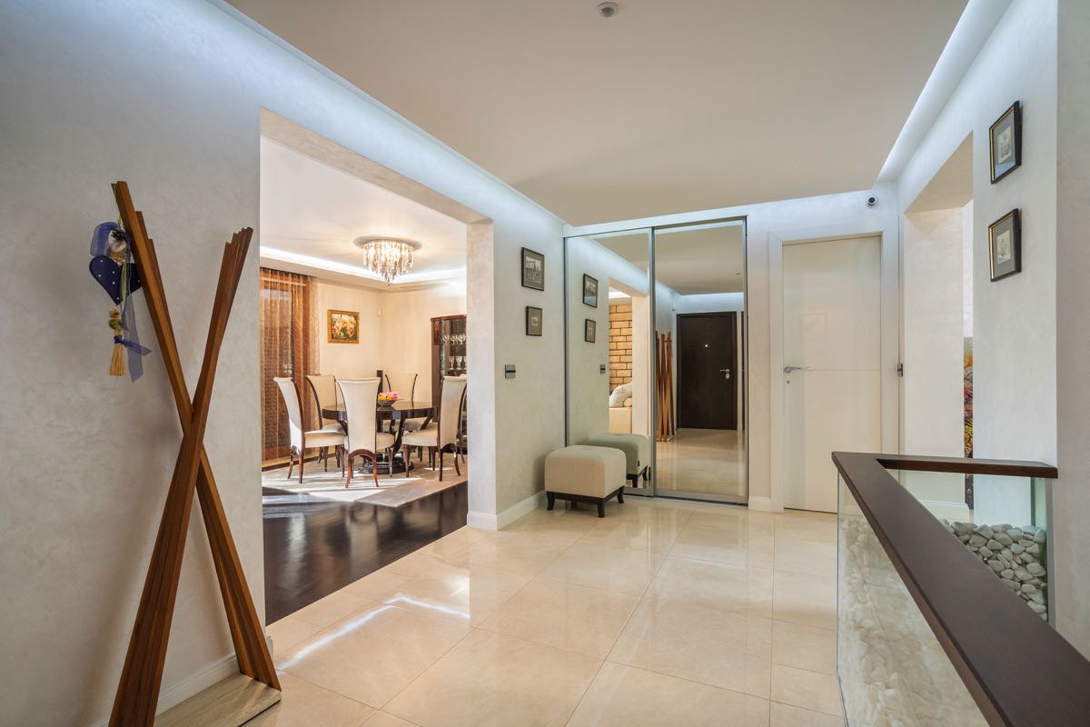 Helle Diele und Essbereich in einer Villa in Budva, Montenegro: Spiegelschrank, Marmorboden und stilvolle Möbel.