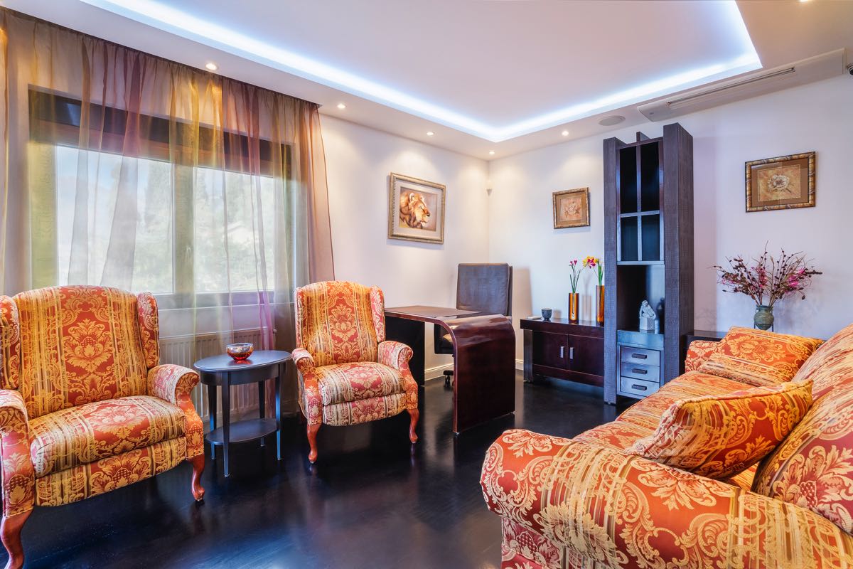 Wohnzimmer mit klassischen Möbeln und dunklem Parkett in einer Villa in Budva, Montenegro: gemütliches Interieur mit farbenfroher Polsterung.