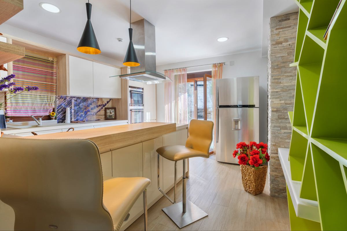 Moderne Küche mit Bartheke und hellem Regal in einer Villa in Budva, Montenegro: stilvolles Interieur und Dekor.