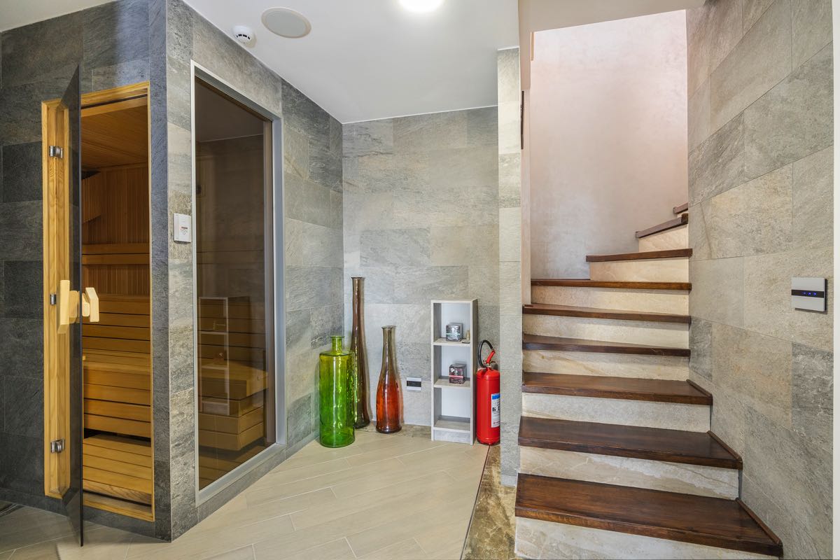 Moderne Sauna und Holztreppe im Interieur der Villa in Budva, Montenegro, mit Steinverkleidung und stilvoller Dekoration.