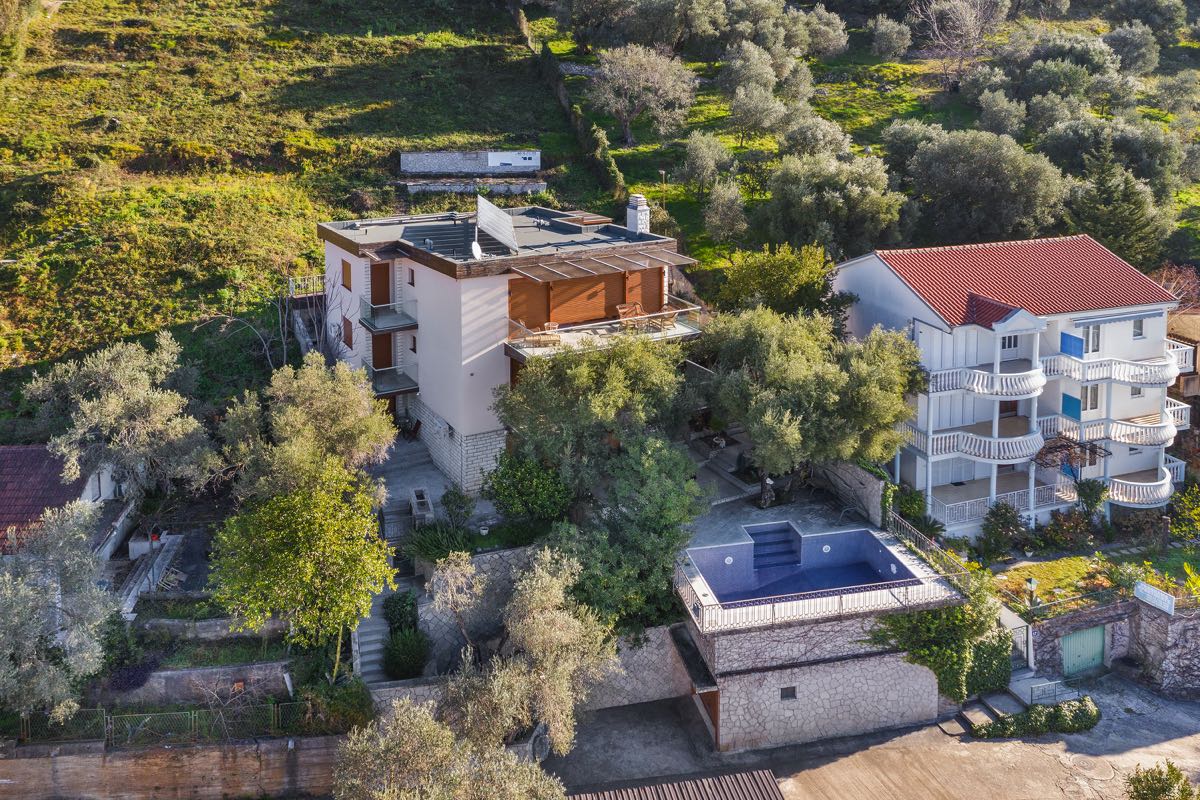 Villa in Budva, Montenegro: Blick auf das Haus mit Terrassen, Olivenhain und privatem Pool am Berghang.
