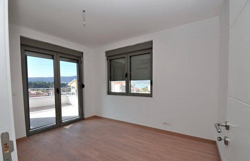 Helles Schlafzimmer mit Zugang zur Terrasse und Meerblick in einer neuen Wohnanlage in Tivat, Montenegro.