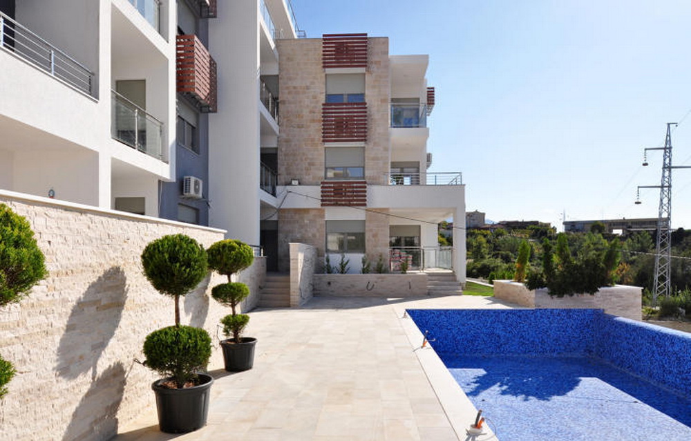 Moderner Wohnkomplex in Tivat, Montenegro: Steinfassade, Terrasse mit Pool und Landschaftsgestaltung.