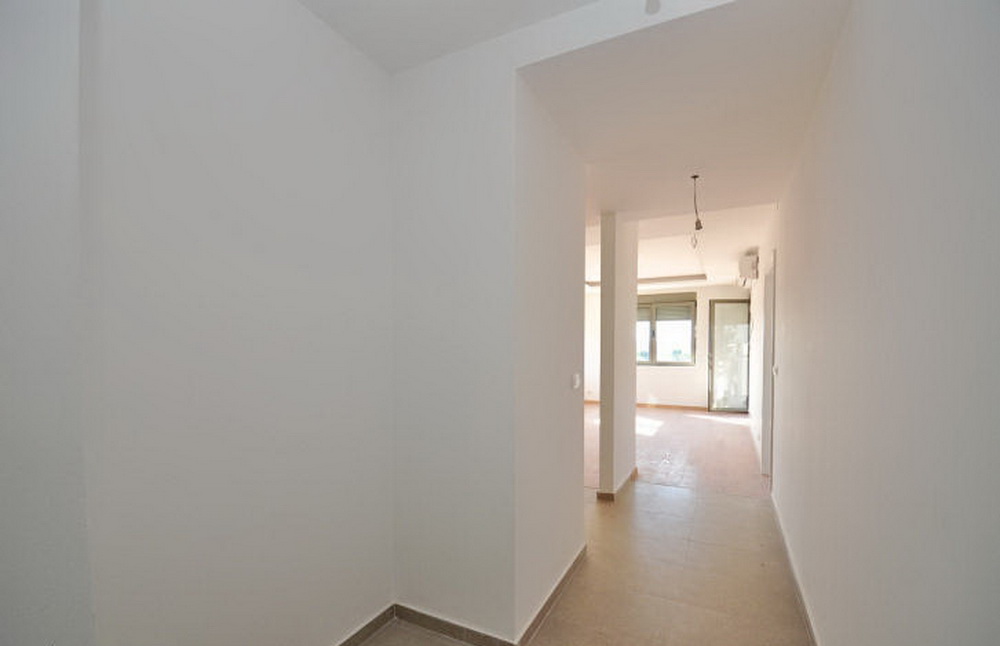 Heller Flur und Wohnzimmer in einem Neubau in Tivat, Montenegro: schlüsselfertige Ausstattung, Fliesenboden, Blick auf das Fenster.