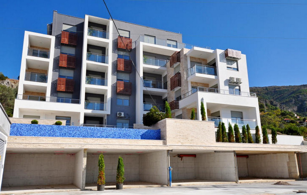 Moderner Wohnkomplex in Tivat, Montenegro: Fassade mit Balkonen, Steinverkleidung und Pool auf dem Gelände.