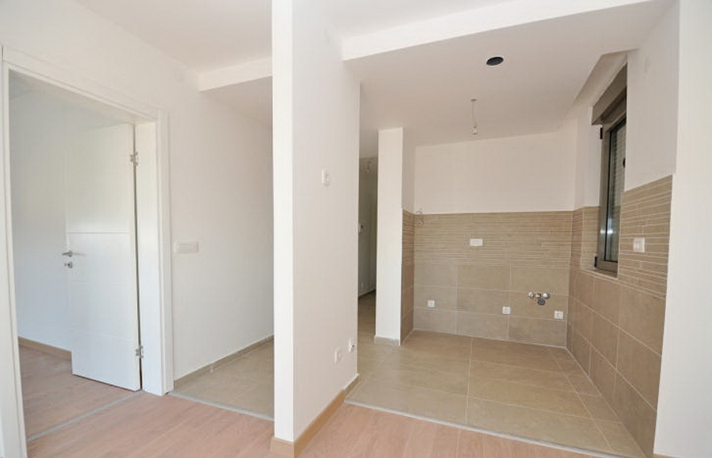 Kücheninterieur mit Fliesenverkleidung in einem Neubau, Tivat, Montenegro. Heller Raum mit Vorbereitung für eine Küchenzeile.