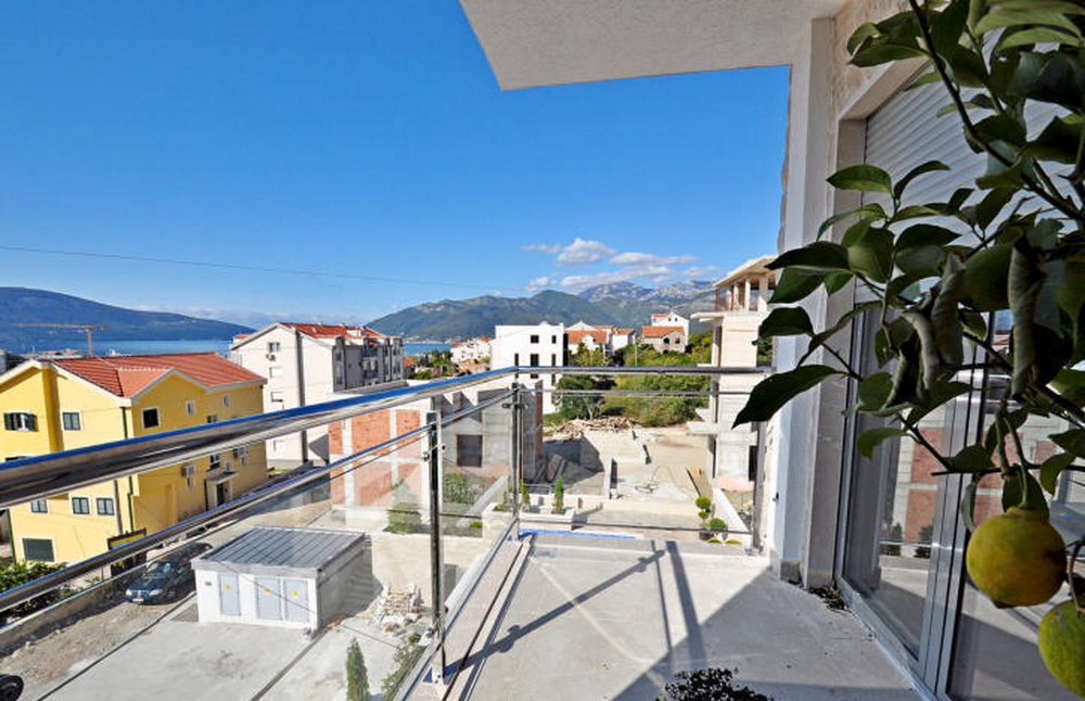Blick vom Balkon einer Wohnanlage in Tivat, Montenegro: Panorama von Bergen, Meer und moderner Bebauung von der Terrasse.