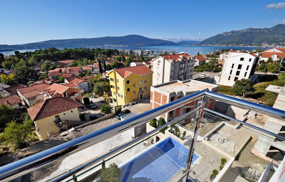 Blick vom Balkon auf den Pool und das Panorama der Stadt Tivat, Montenegro: moderne Wohnanlage mit Meerblick.