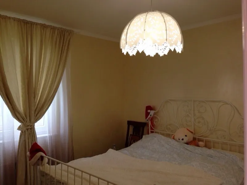 Przytulna sypialnia z kutym łóżkiem i ażurową lampą w willi w Šušanj, Czarnogóra. Jasne tony, klasyczny styl.