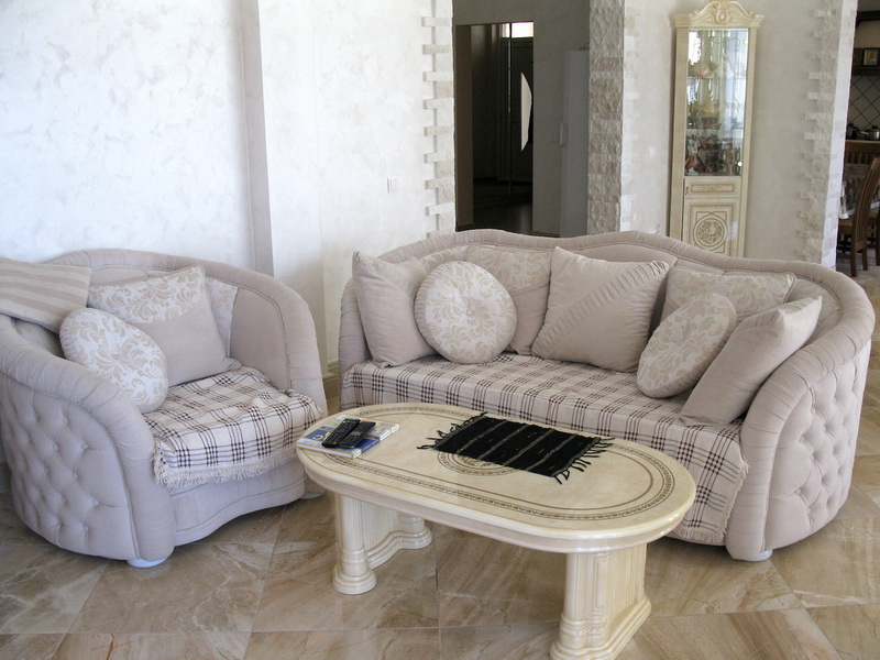 Salon d’une villa à Šušanj, Monténégro : mobilier rembourré clair, intérieur classique et finitions en pierre.