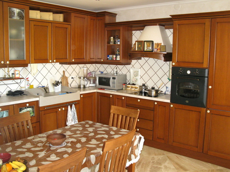 Cuisine classique en bois massif dans l’intérieur d’une villa à Šušanj, Monténégro : électroménager intégré et coin repas.