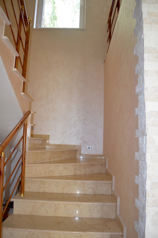 Escalier avec marches en marbre et rampe en bois dans l’intérieur d’une villa à Shushan, Monténégro.