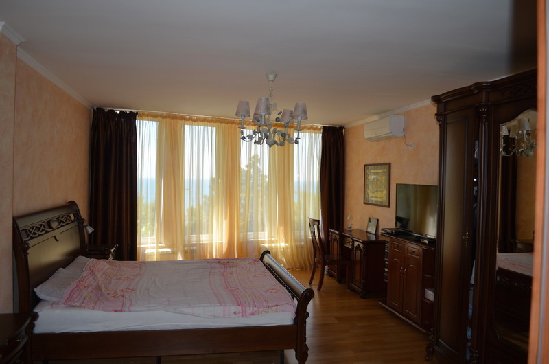 Chambre avec mobilier classique en bois foncé et vue sur la mer dans une villa à Šušanj, Monténégro.