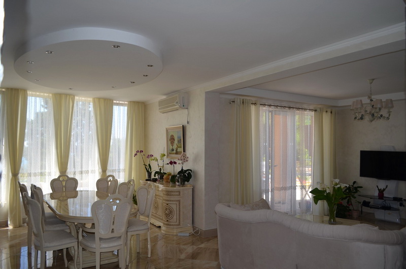 Salon spacieux avec coin repas et mobilier clair dans une villa à Šušanj, Monténégro, avec accès à la terrasse.