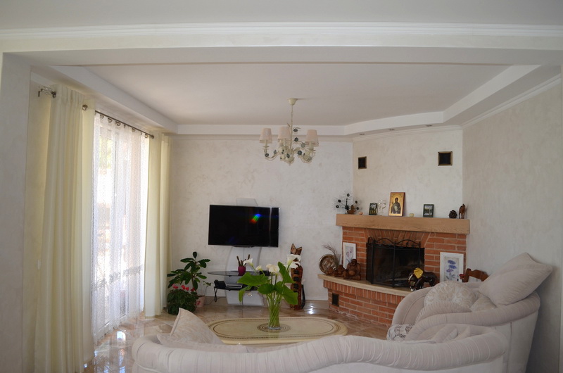 Salon avec cheminée et mobilier moelleux dans l’intérieur d’une villa à Šušanj, Monténégro. Design lumineux, baie vitrée panoramique.