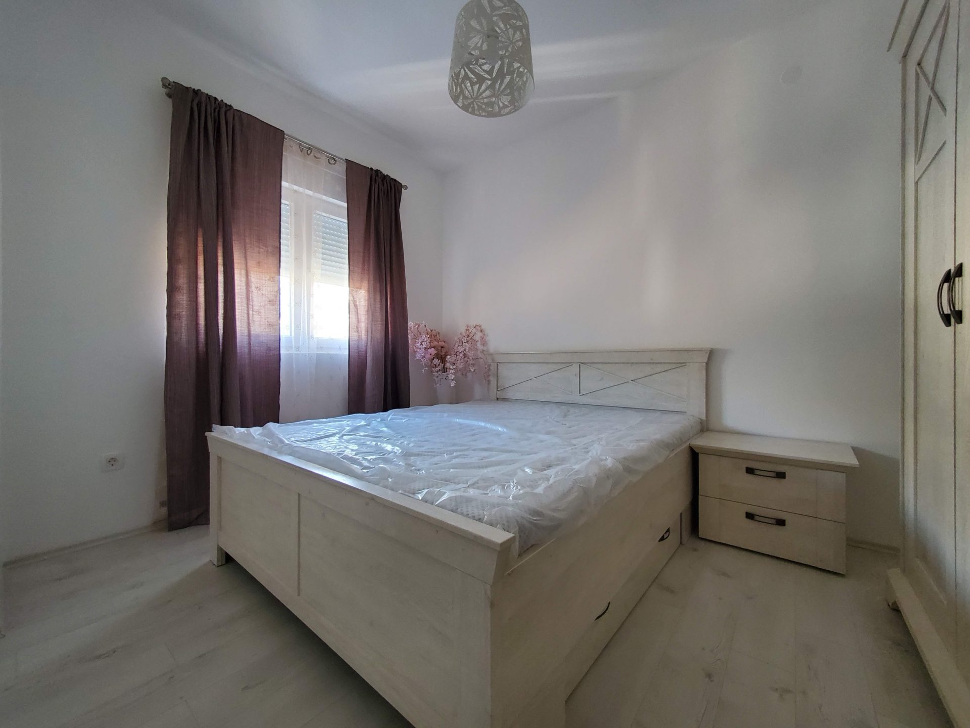 Helles Schlafzimmer mit Doppelbett und Kleiderschrank in einer zum Verkauf stehenden Wohnung in Budva, Montenegro.