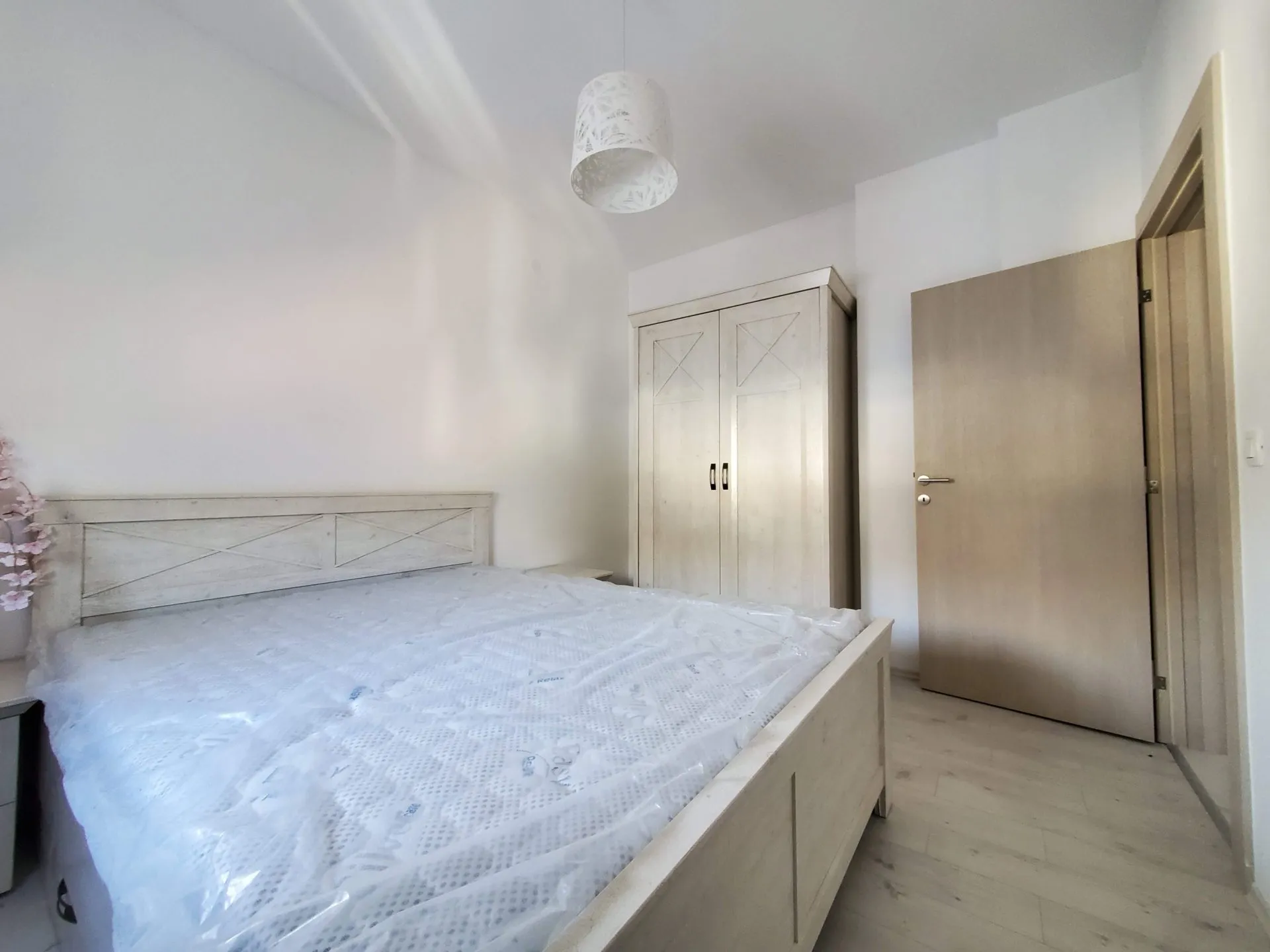Helles Schlafzimmer in einer Wohnung in Budva, Montenegro: Doppelbett mit neuer Matratze, Kleiderschrank und Innentür.