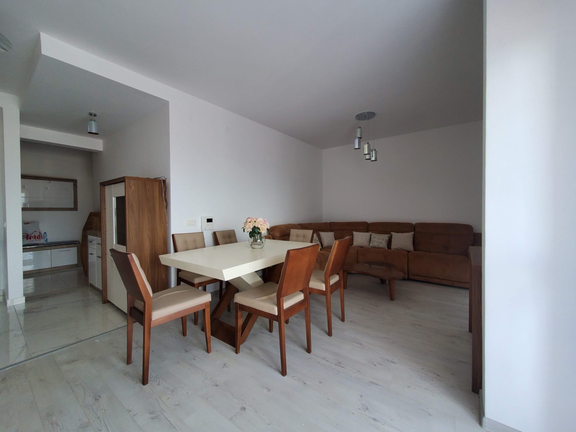 Wohnzimmer mit Essbereich und braunem Sofa in einer Wohnung in Budva, Montenegro. Modernes Interieur mit Möbeln.