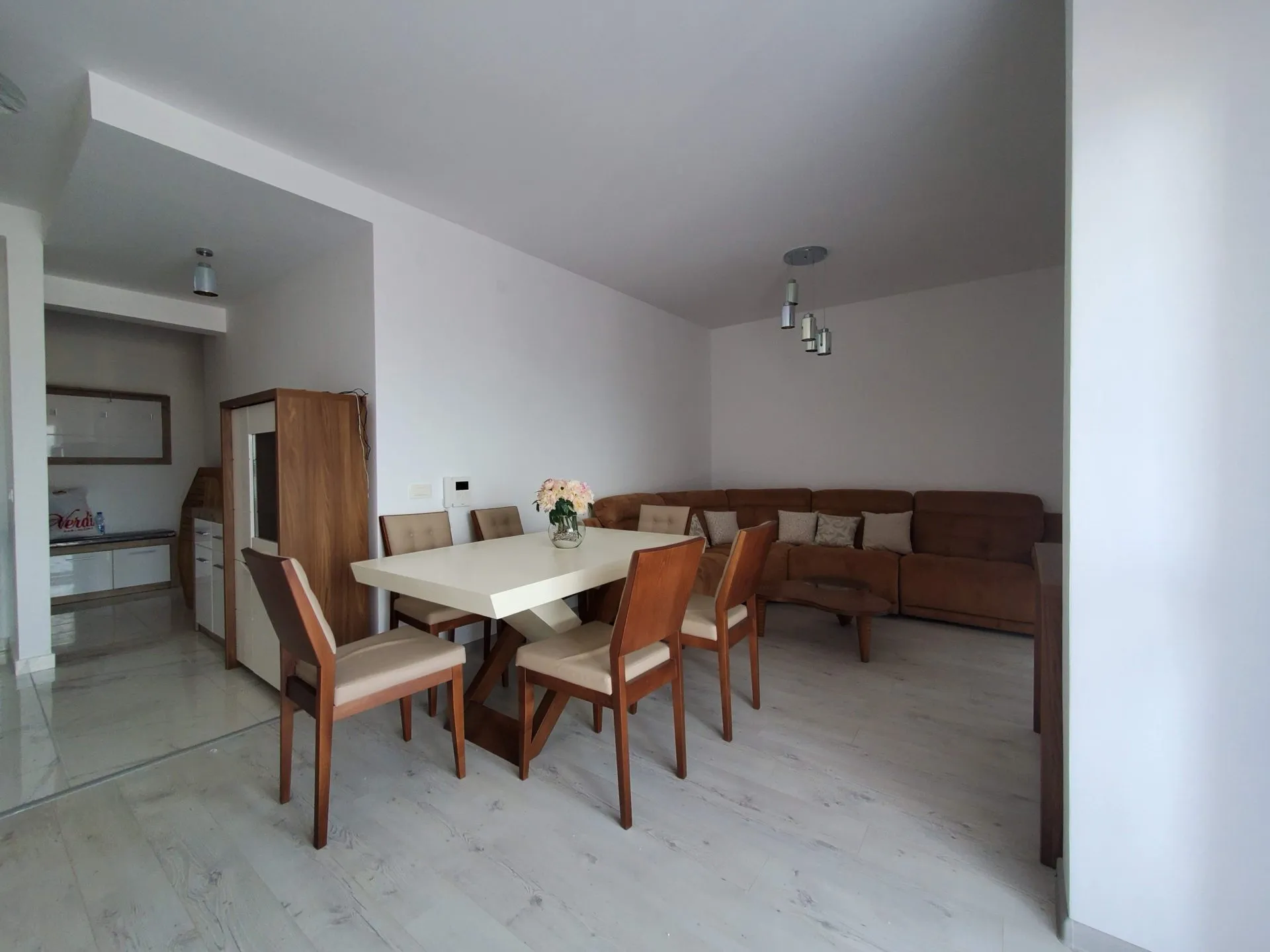 Wohnzimmer mit Essbereich und braunem Sofa in einer Wohnung in Budva, Montenegro. Modernes Interieur mit Möbeln.