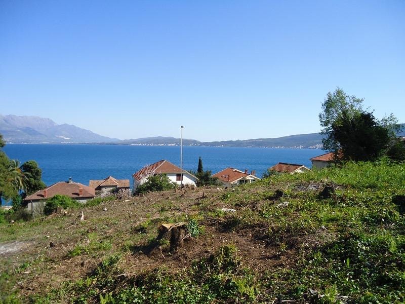 Karadağ, Bijela’da, deniz ve dağların panoramik manzarasına sahip, güneşli bir günde imara uygun arsa.