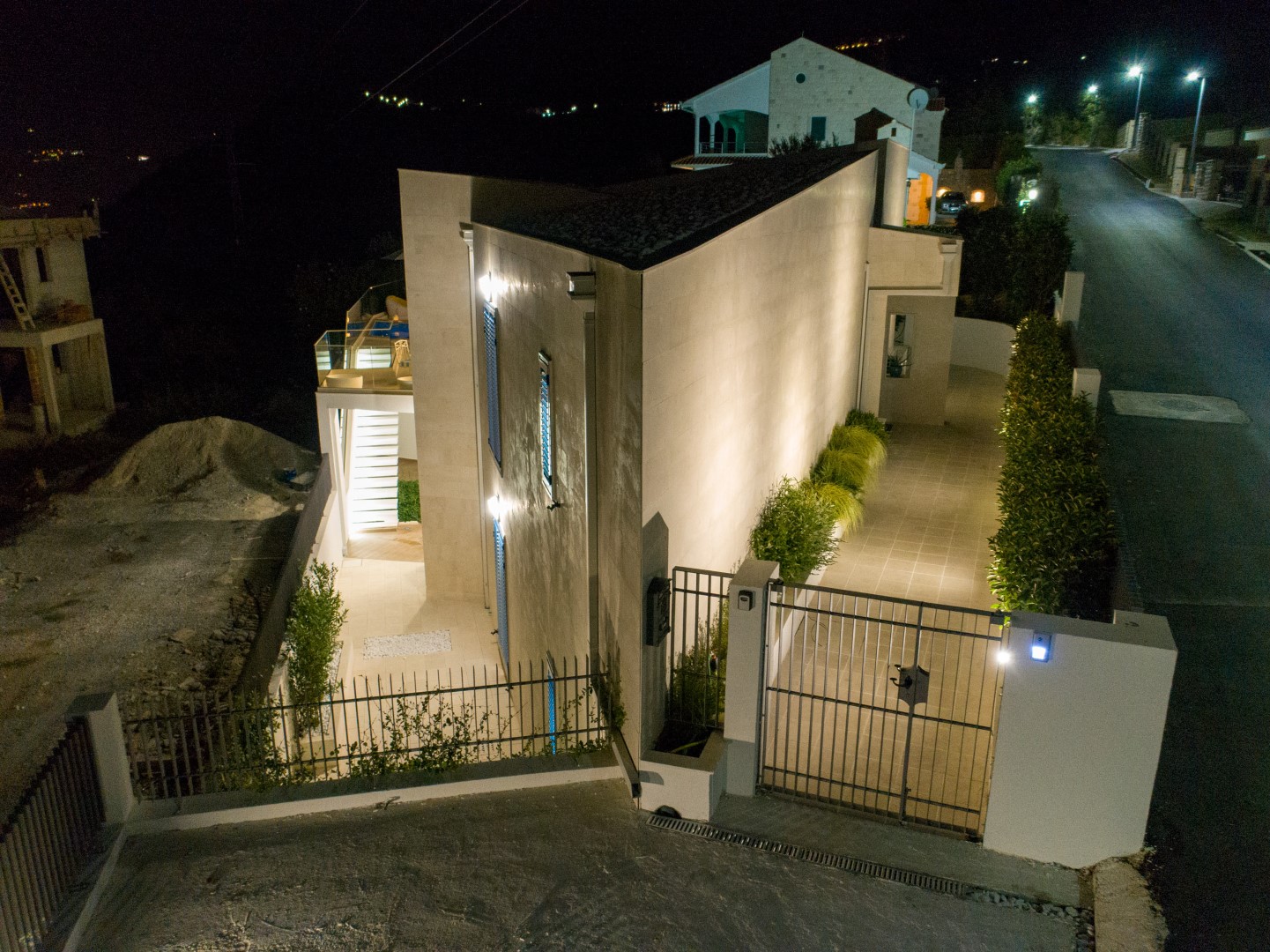 Современная вилла с ночной подсветкой и бассейном в Близикуче, Черногория: вид снаружи на дом с огороженной территорией.