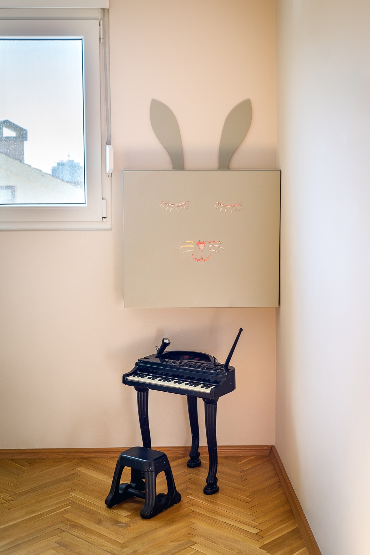 Kinderzimmer in einer Wohnung in Budva, Montenegro: Wanddekoration in Form eines Hasen, Kinderklavier und Parkettboden.