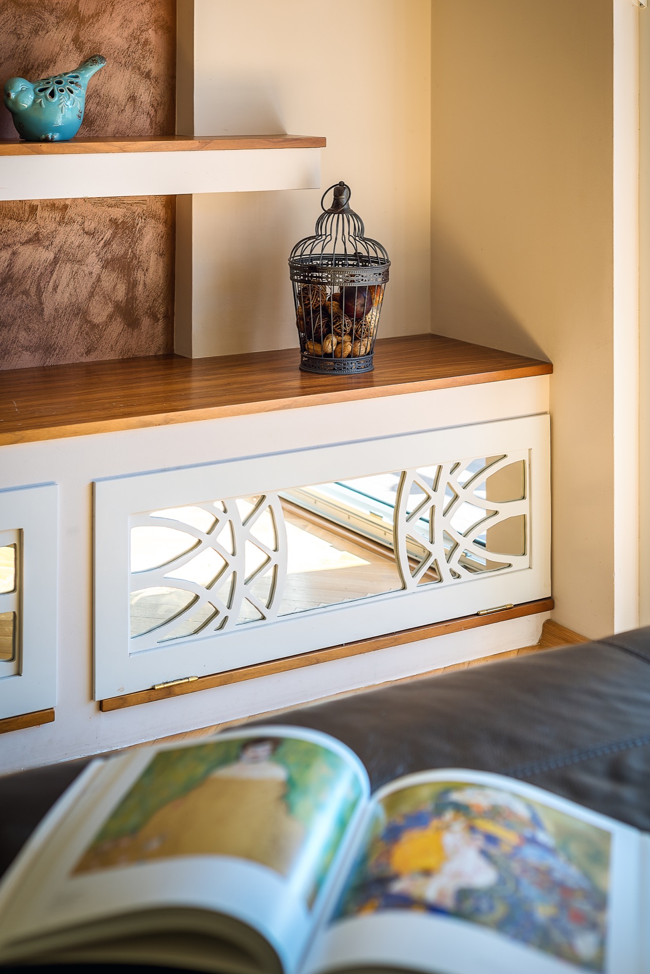 Wohnzimmerdekor in einer Wohnung in Budva, Montenegro: ein Holzsideboard mit geschnitzten Fronten und stilvolle Accessoires.