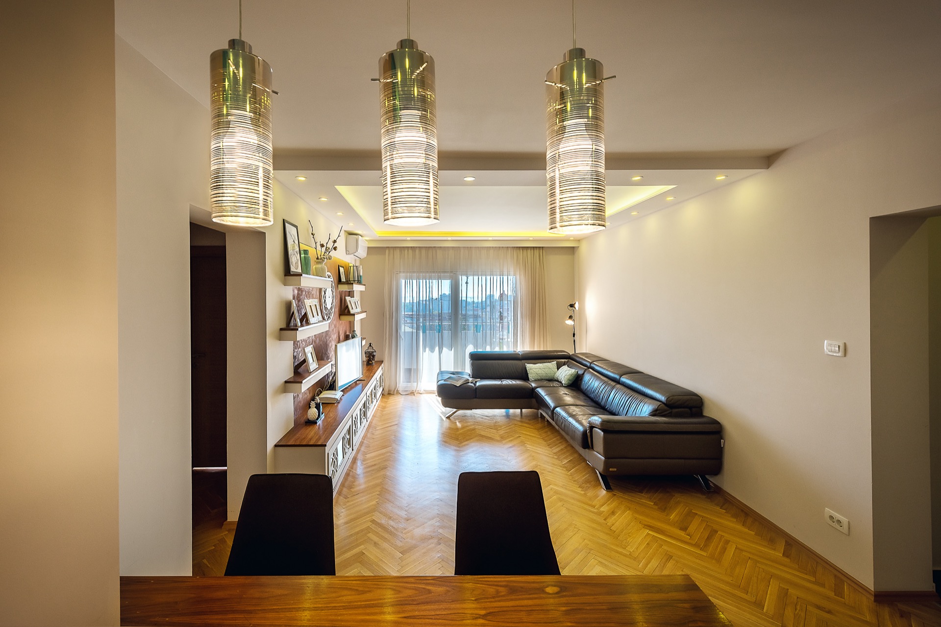 Modernes Wohnzimmer mit Ledersofa und Parkett in einer Wohnung zum Verkauf, Budva, Montenegro.