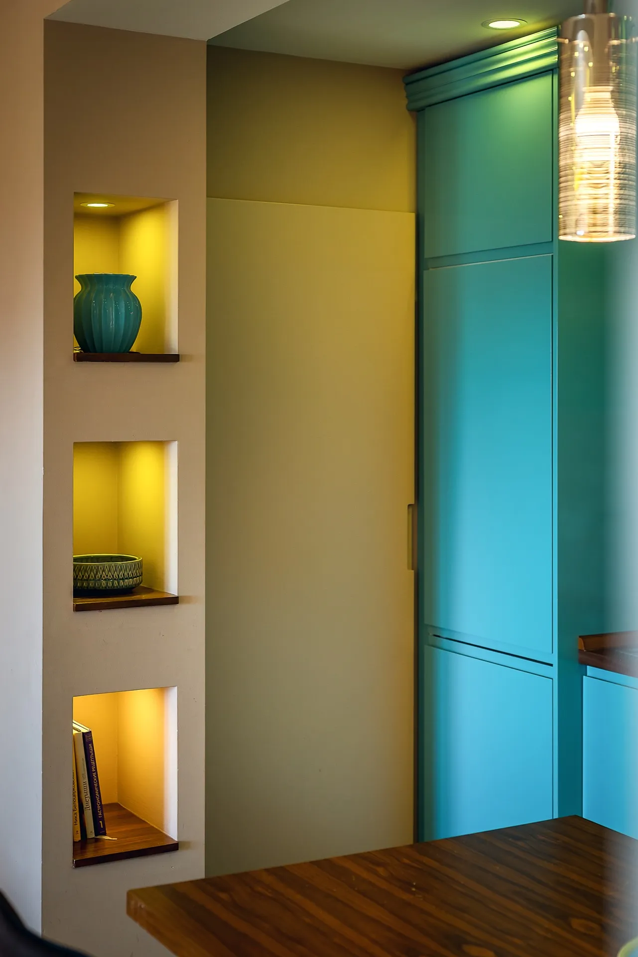 Modern kitchen in an apartment in Budva, Montenegro: turquoise cabinet fronts, built-in niches with lighting, and decor.